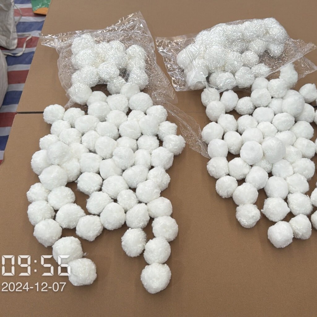 Checking Moisture Levels in Polyester Fiber Balls Checking moisture levels and loftiness of polyester fiber balls during inspection.