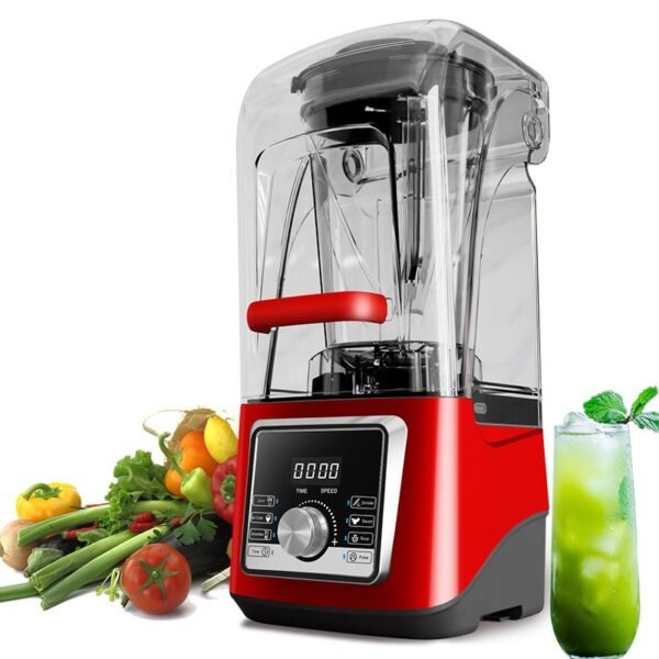 Red juicer blender side view, next to a green vegetable smoothie and fresh produce