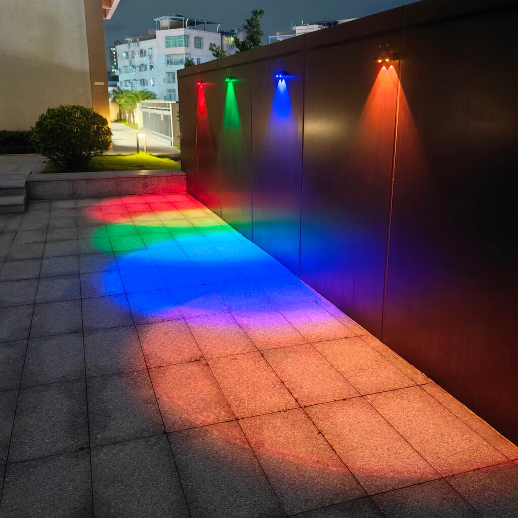 RGB solar fence light showing red green blue and other color lighting effects on an outdoor wall at night