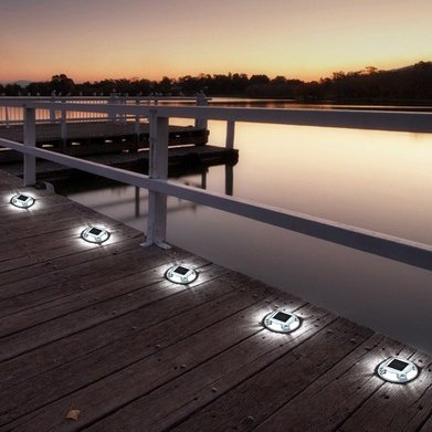 Solar studs installed on waterfront dock boardwalk at night