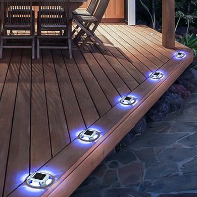 Solar lights installed on wooden deck path in residential garden at night
