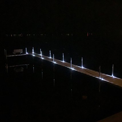 Solar dock lights lighting a dark seaside or dockside bridge at night