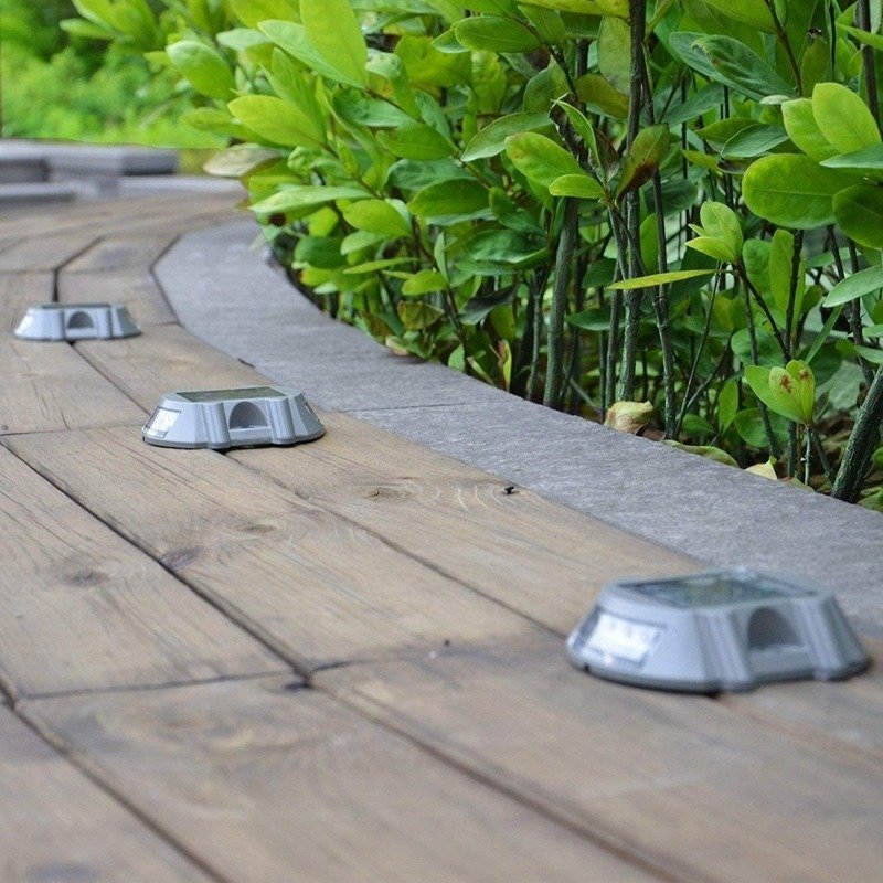 Solar road studs installed on pavement walkway during daytime