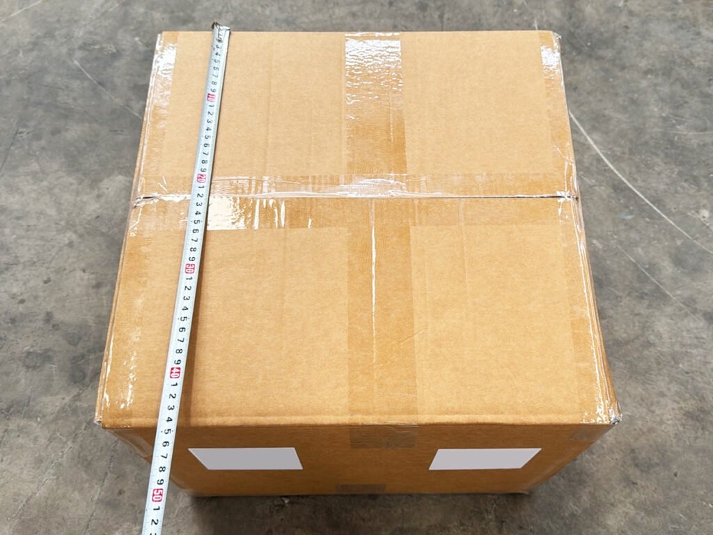 JXNUO staff measuring carton dimensions during packaging consistency checks.