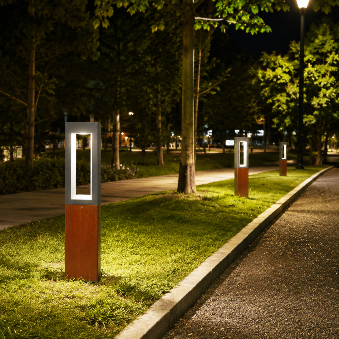 Open-frame LED landscape bollard lights illuminating a park pathway and roadside at night