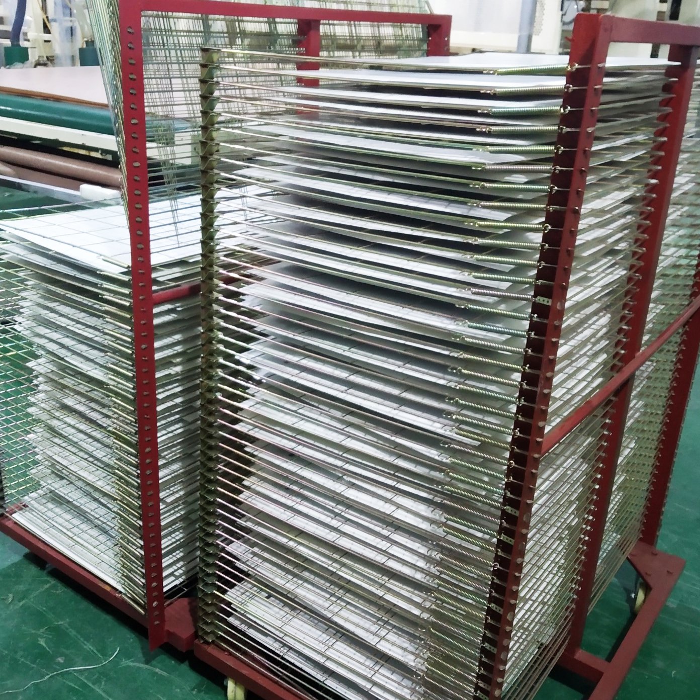 Small solar panel modules arranged on production racks inside a factory